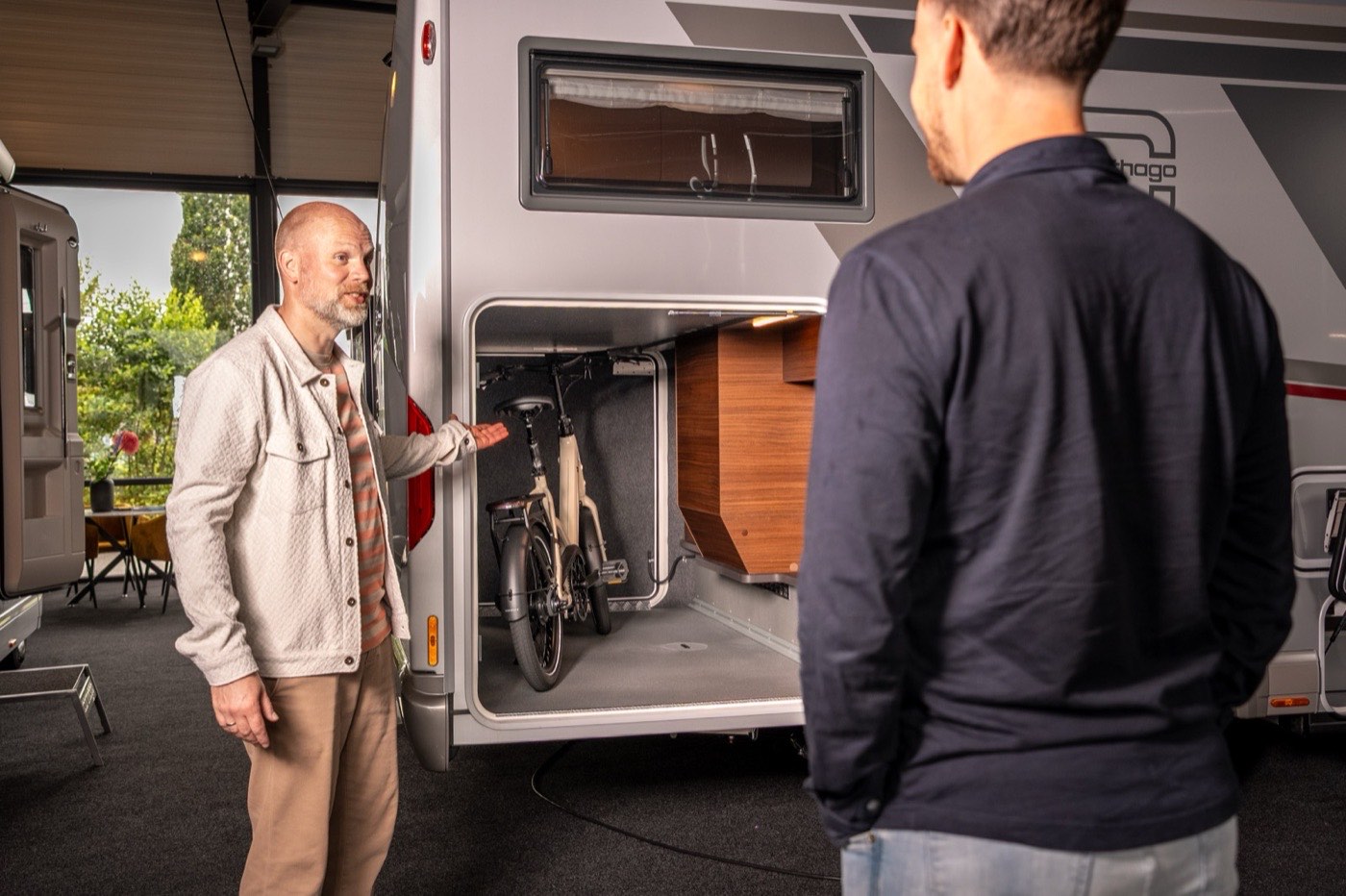 Een fiets staat dwars in de garage van de chic c-line terwijl die aan een bezoeker wordt getoond