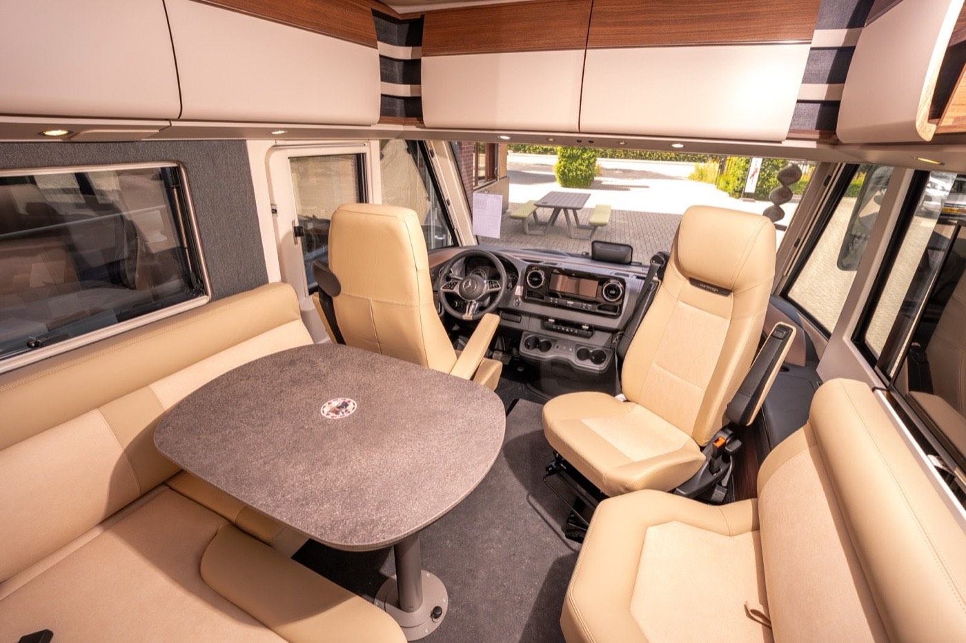 Het lichte interieur van de chic c-line in de showroom van Stijkel Campers, met zitgroep en cabinestoelen